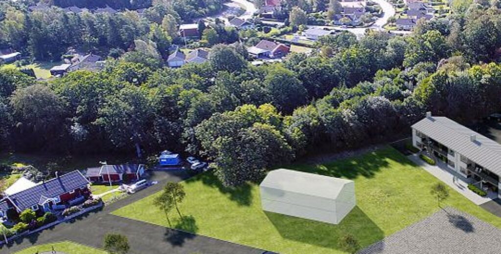 En flygvy över ett samhälle med öppna grönytor där GBJ Bygg medverkar i utvecklingen av nya bostadsmiljöer som harmonierar med naturens struktur och landskap.