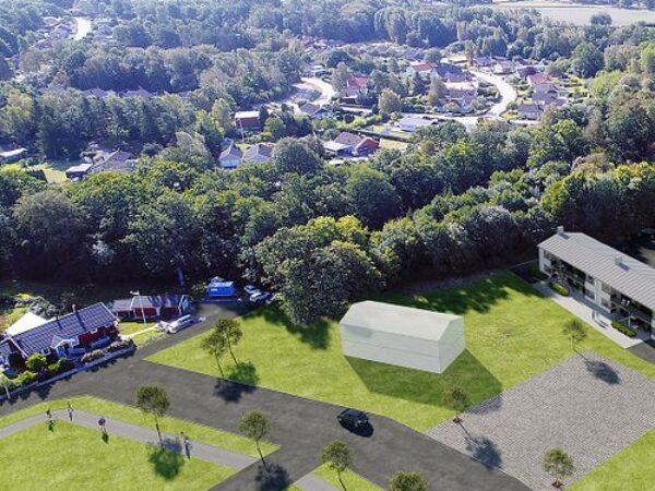 En flygvy över ett samhälle med öppna grönytor där GBJ Bygg medverkar i utvecklingen av nya bostadsmiljöer som harmonierar med naturens struktur och landskap.