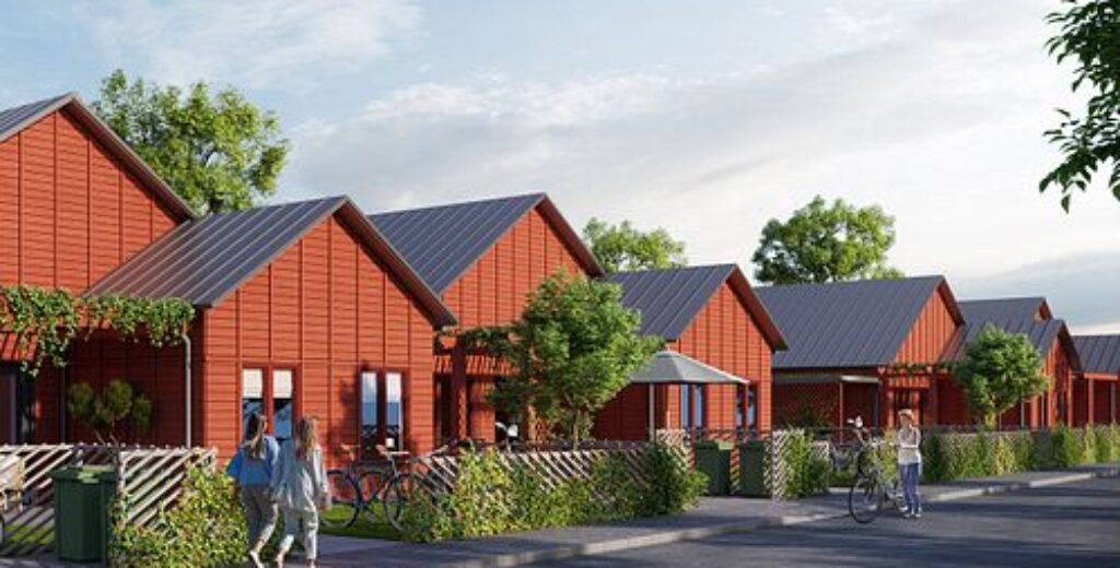 En rad moderna småhus med röda fasader och gröna omgivningar där GBJ Bygg utvecklat ett tryggt bostadsområde med fokus på gemenskap, materialkvalitet och genomtänkt placering i landskapet.