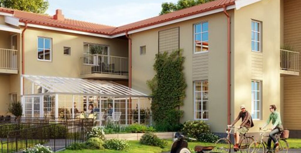 Ett flerbostadshus i klassisk stil med välskötta gräsytor där GBJ Byggs fokus på estetisk kvalitet och boendemiljö kommer fram i byggnadens proportioner och detaljer.