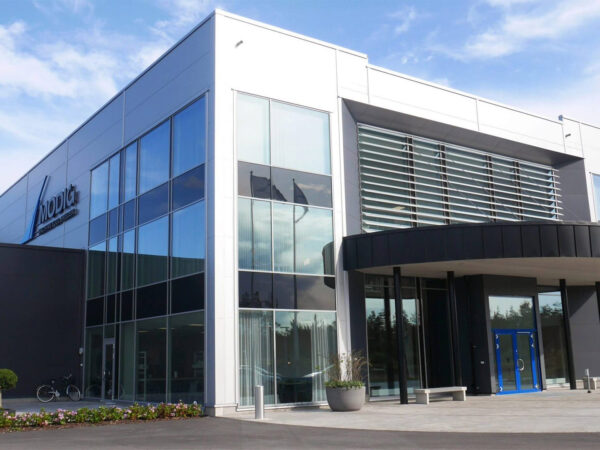 Entrépartiet till en modern industribyggnad med stora glasfasader och tydlig arkitektur framhäver hur GBJ Bygg skapat en representativ och funktionell anläggning anpassad för Modig Machines verksamhet.