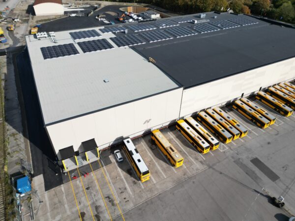 En lager- och logistikbyggnad i ljusa toner sedd från marknivå, där GBJ Byggs arbete med storskalig konstruktion och energieffektiva fasader framträder tydligt.