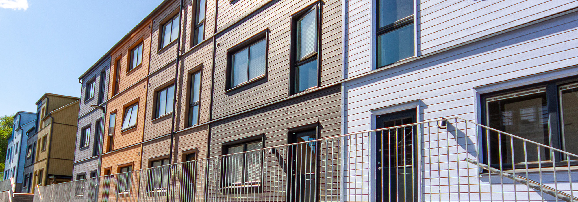 Fasadvyn visar variation i fönstersättning och träpanel, där GBJ Bygg skapat en levande och strukturerad gestaltning som ger bostadshusen både rytm och karaktär.