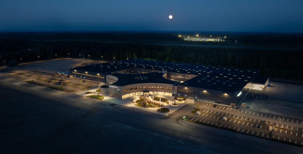 Flygbild i kvällsljus visar Micropower-anläggningen och dess kringliggande ytor, där GBJ Bygg har utformat en modern och storskalig industrimiljö anpassad för avancerad teknikproduktion.