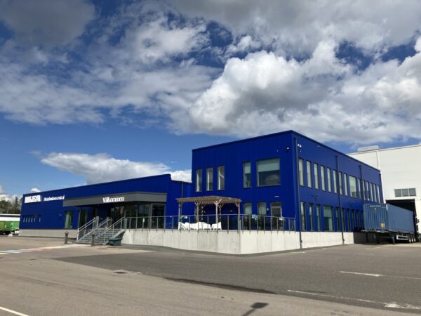 En blå kontors- och verksamhetsbyggnad vid IKEA DC Syd, med entré, stora fönster och lastområde. GBJ bygg har bidragit till anläggningen, som kombinerar representativa personalytor med funktioner för logistikverksamhet.
